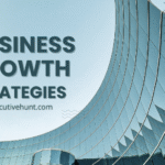 Modern glass building reflecting sky with bold text “Business Growth Strategies” representing executive placement and corporate growth.